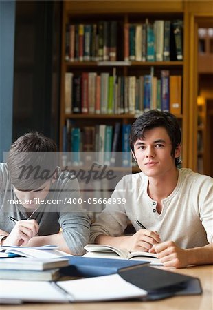 Portrait of students working on an essay in a library