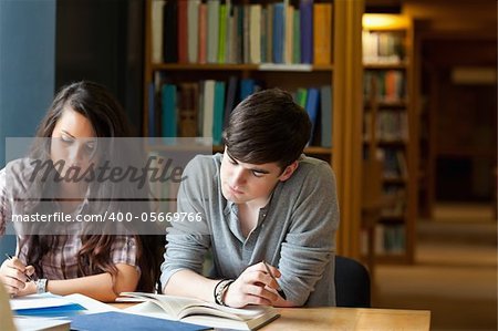 Students writing an essay in a library
