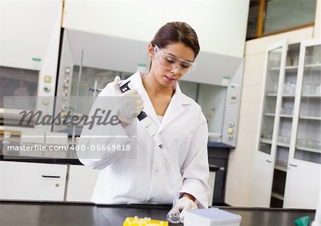 Scientist pouring a liquid in an Erlenmeyer flask in a laboratory