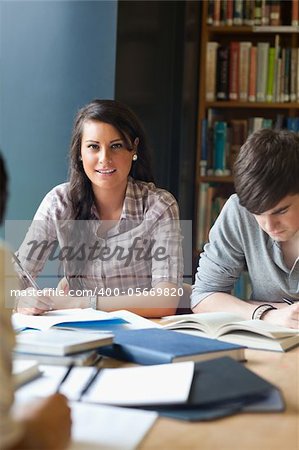 Portrait of young adults studying in a library