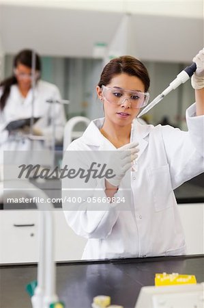 Portrait of a student pouring a liquid in a tube in a laboratory