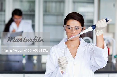 Female scientist pouring a liquid in a tube in a laboratory