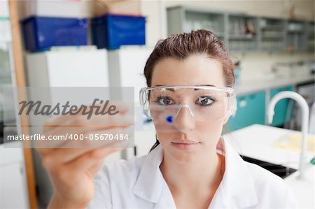 Cute science student looking at a microscope slide in a laboratory