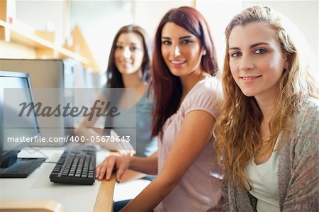 Fellow students posing with a computer in with the camera focus on the foreground model