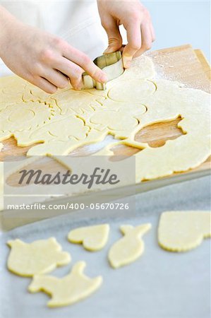 Woman using cookie cutter and baking homemade cookies