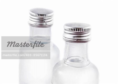 Two bottles filled with liquor on white background