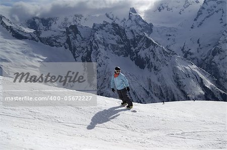 Snowboarder on ski slope. Ski resort. Caucasus Mountains, Dombay