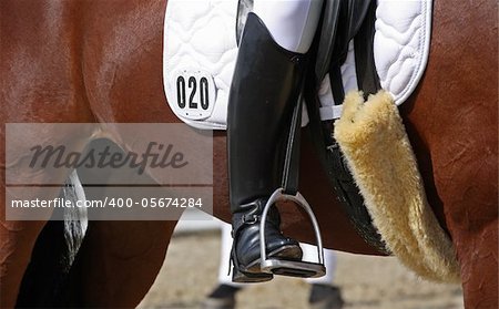 Human leg in boot on horseback