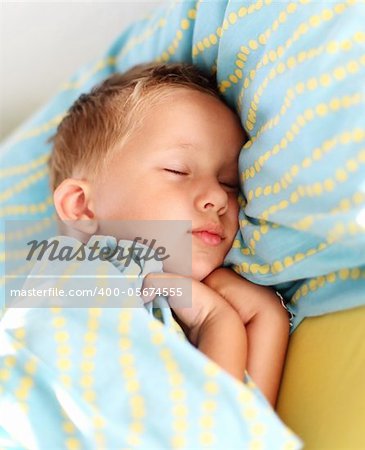 Little boy sleeping peacefully in bed