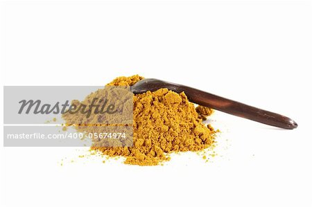 yellow, spicy curry mixture with a spoon on white background