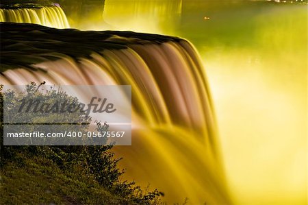 The American Niagara Falls appear totally covered in yellow light.