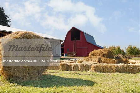 Roll of Hay by the Red Barn with Blue Sky