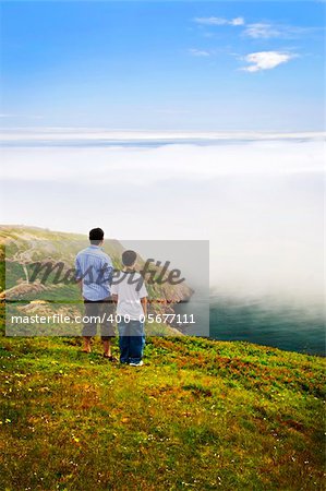 Father and son looking at foggy ocean view in Newfoundland