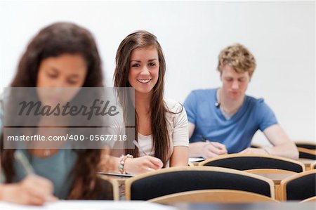 Smiling young students sitting on a chair in an amphitheater