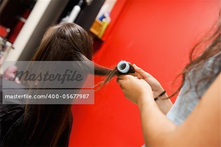 Hairdresser rolling hair with a curler
