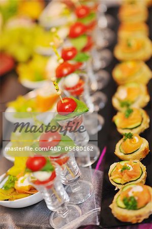 buffed food closeup of  fruits, vegetables, meat and fish arranged on banquet table