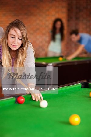 Portrait of a cute woman playing snooker in a home student