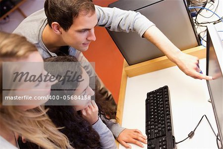 Fellow students using a computer in an IT room