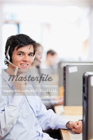 Portrait of an operator posing with a headset in a call center