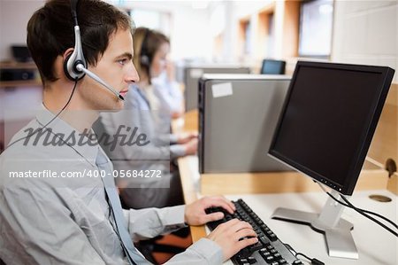 Portrait of a smiling blonde operator posing with a headset in a call center