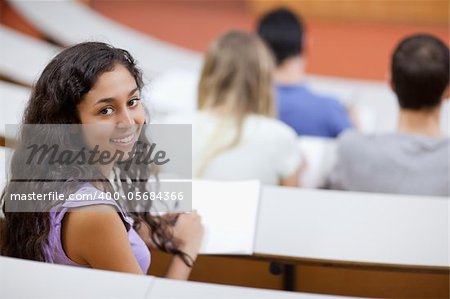 Cute student being distracted in an amphitheater