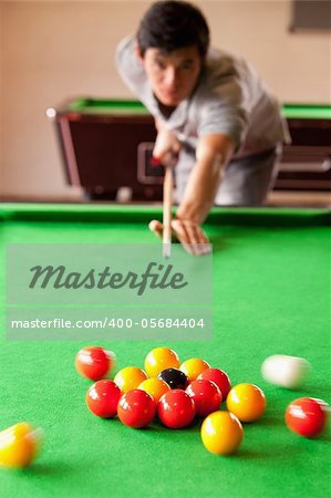 Portrait of a man playing snooker with the camera focus on the balls