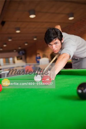 Portrait of a student playing pool in a student home