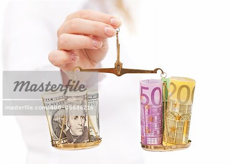 Currency rate risk concept - woman hand with euro and dollar on balance