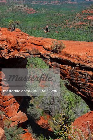 Hiker girl jumping in Devils bridge, Sedona Arizona