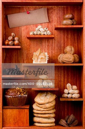 Assortment of different nuts and foods with nuts in them in a wooden shelf. Add your text to the brown paper.