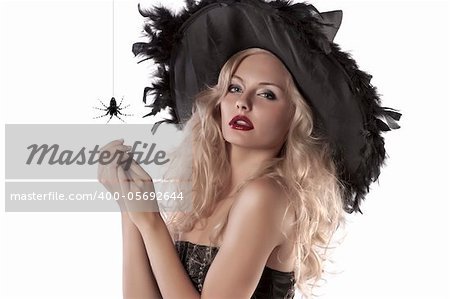 close up portrait of a young blonde girl dressed as a witch posing with a huge spider