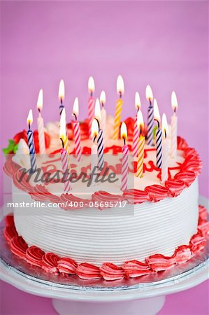 Birthday cake with lit candles and white icing