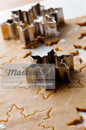 Making gingerbread cookies for Christmas. Gingerbread dough with star shapes and a cutter.