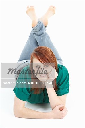 Portrait Of Smiling Teenage Girl Laying On Stomach