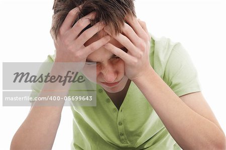 A teenager with head in hands wincing from pain of migraine, stress, anguish or depression.  White background.