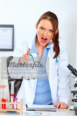 Angry medical doctor woman shouting and pointing on you