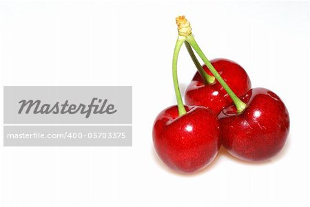 three fresh red cherries in the summer on white background