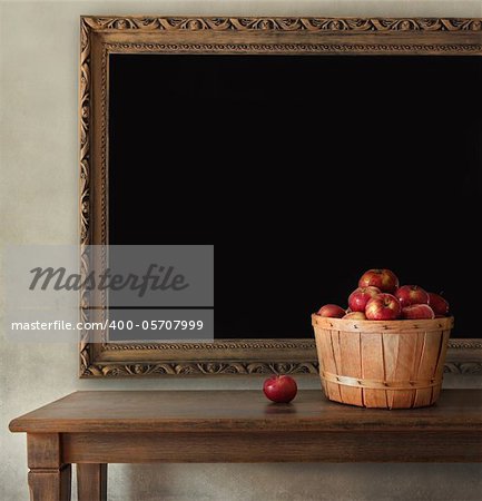 Fresh apples on wooden table with blackboard
