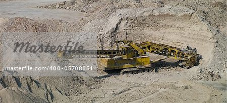 huge bulldozer in the sand quarry produces material