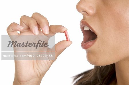 pretty young women pops a pill into her mouth