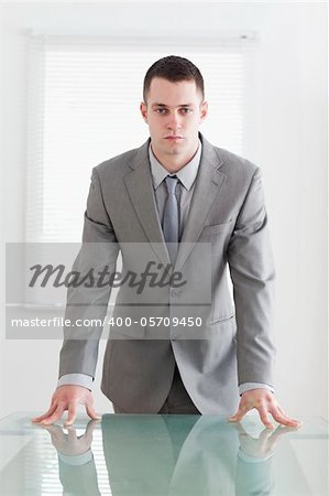 Confident business man standing behind a table