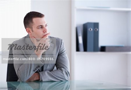 Businessman thinking and sitting behind a table