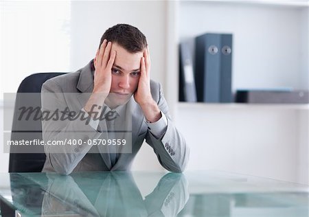 Disappointed businessman sitting behind a table