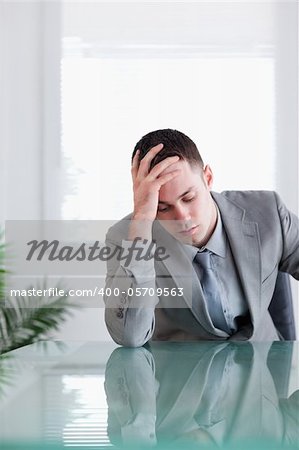 Close up of businessman that got bad news sitting behind a table