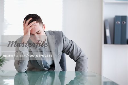 Businessman got bad news and is sitting behind a table