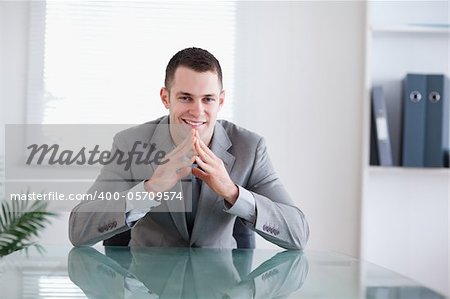 Young businessman smiling sitting behind a table