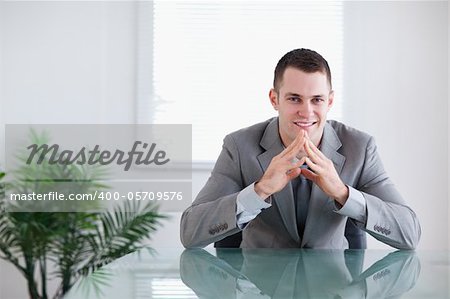 Young businessman getting good news sitting behind a table