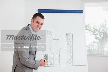 Smiling young businessman editing column graph