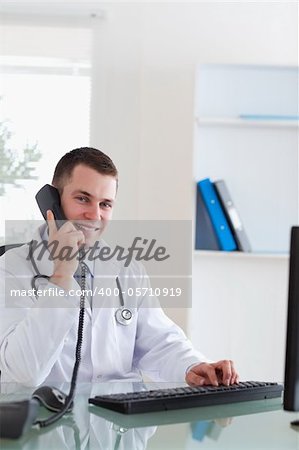 Smiling doctor talking with patient on the telephone