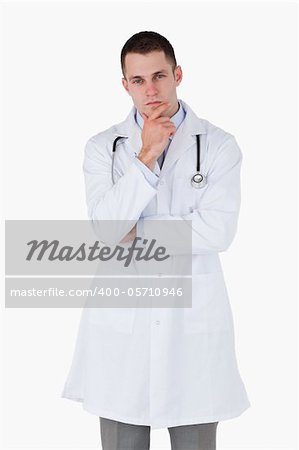 Thinking young doctor on white background